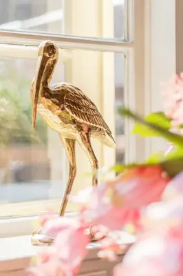 a statue of a bird standing on a window sill at Abbey Abcoude in Abcoude
