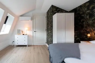 a bedroom with a bed and a black and white wall at Luxe 3-kamer Penthouse met dakterras in het centrum van Hoorn in Hoorn