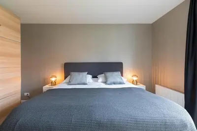 a bedroom with a large bed with two lamps at Luxe 3-kamer Penthouse met dakterras in het centrum van Hoorn in Hoorn