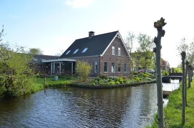 a house on the side of a river at Bed and breakfast Hoeve Spoorzicht in Papekop