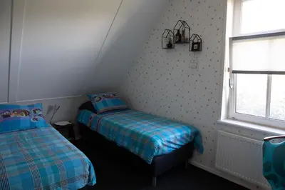 a small bedroom with a bed and a window at Bed and breakfast Hoeve Spoorzicht in Papekop
