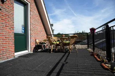 a patio with a table and chairs on a balcony at Bed and breakfast Hoeve Spoorzicht in Papekop