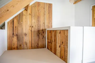 a room with wooden walls and a vaulted ceiling at By Tons Huisje inclusief twee fietsen in Zegveld