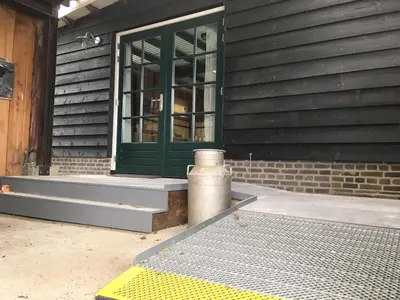 a building with a green door and a window at Boerderij Honswijck in Weesp