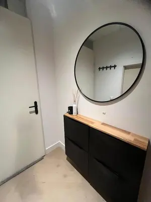 a bathroom with a black dresser and a mirror at WaalPlaat's B&B in Amsterdam