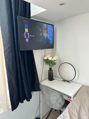 a room with a desk with a tv on a wall at WaalPlaat's B&B in Amsterdam