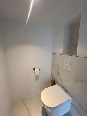a white bathroom with a toilet and a mirror at WaalPlaat's B&B in Amsterdam