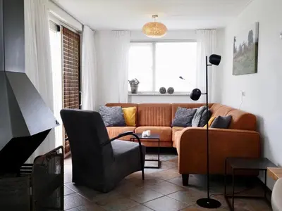a living room with a couch and a chair at Vakantiehuis Camperduin in Schoorl