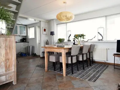 a dining room with a wooden table and chairs at Vakantiehuis Camperduin in Schoorl