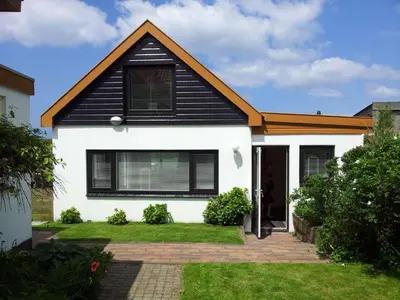a house with a black and white at Vakantiehuis Camperduin in Schoorl