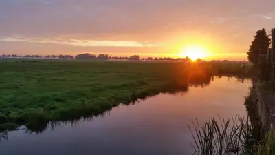 a sunset over a river in a field at Guesthouse Purmerend near Amsterdam Volendam in Purmerend
