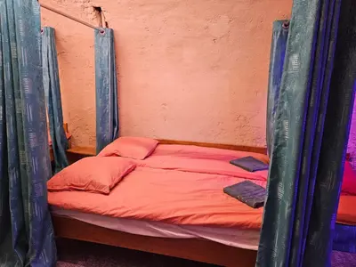 a bed in a tent with orange sheets at Overnachten aan de Werf in Utrecht