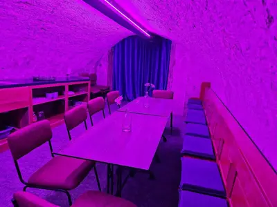 a purple room with tables and chairs with purple lights at Overnachten aan de Werf in Utrecht