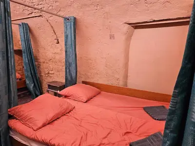 a bed with two red pillows in a room at Overnachten aan de Werf in Utrecht