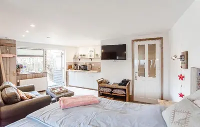 a bedroom with a bed and a living room at Beachstudio in Zandvoort