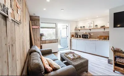 a living room with a couch and a kitchen at Beachstudio in Zandvoort