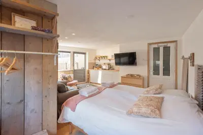 a bedroom with a large white bed and a couch at Beachstudio in Zandvoort