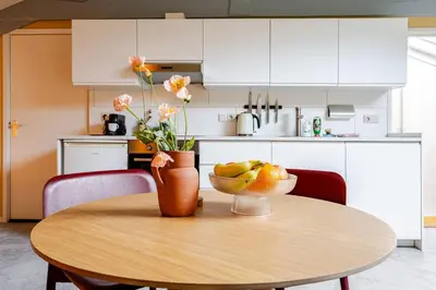 a kitchen with a wooden table with a bowl of fruit on it at Familielogement De Oude Beltoren in Utrecht