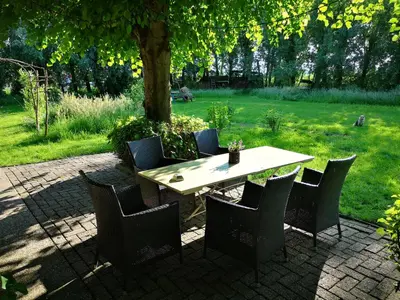 a table and chairs sitting under a tree at Modern Cozy Asian Style bedroom with Kingsize Spa bath in Westbeemster