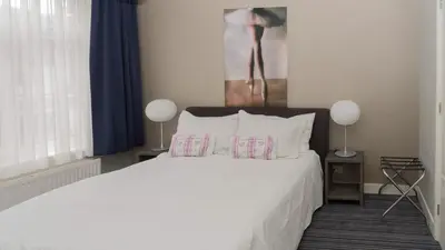 a bedroom with a bed with white sheets and pillows at B&B House No 7 in Amsterdam