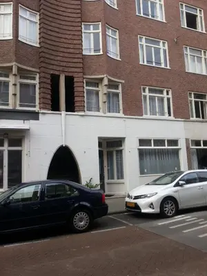 two cars parked in a parking lot in front of a building at B&B House No 7 in Amsterdam