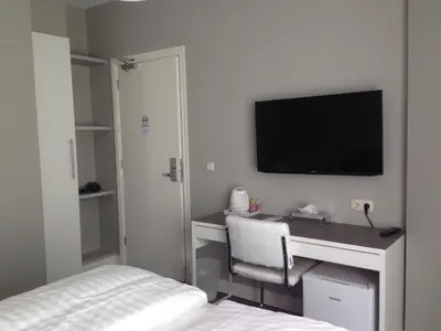 a bedroom with a desk with a television on the wall at B&B House No 7 in Amsterdam