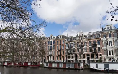 a large building next to a river with buildings at B&B House No 7 in Amsterdam