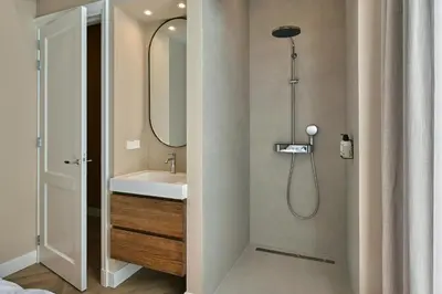a bathroom with a shower with a sink and a mirror at Jorisz Apartments in Haarlem
