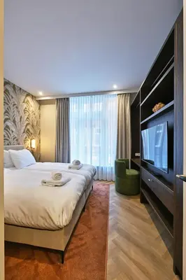 a hotel room with a bed and a flat screen tv at Jorisz Apartments in Haarlem