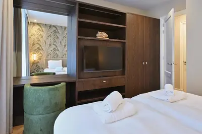 a hotel room with two beds and a television at Jorisz Apartments in Haarlem