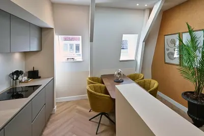 a kitchen with a table and chairs in a room at Jorisz Apartments in Haarlem