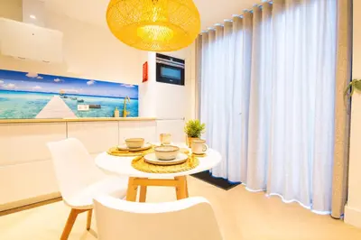 a table and chairs in a kitchen with a window at Vakantie in Noordwijk in Noordwijk