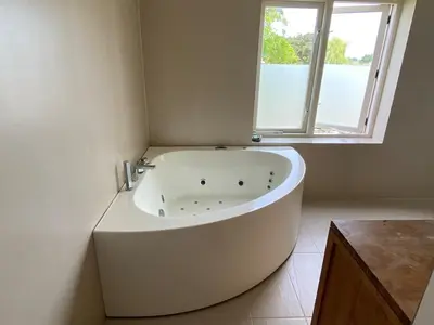 a white bath tub in a bathroom with a window at Villa free standing 25 min Amsterdam 10 min beach in Akersloot
