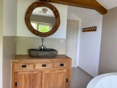 a bathroom with a stone sink and a mirror at Villa free standing 25 min Amsterdam 10 min beach in Akersloot