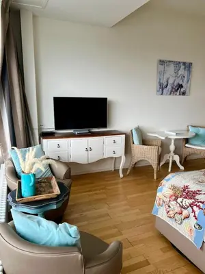 a living room with a tv and a couch and a chair at Annet's Studio in Zandvoort