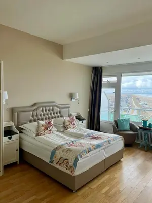 a bedroom with a large bed and a large window at Annet's Studio in Zandvoort