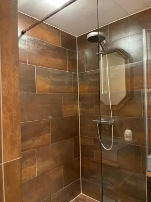 a bathroom with a shower with a glass door at Annet's Studio in Zandvoort