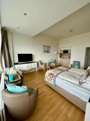 a large bedroom with a large bed and a couch at Annet's Studio in Zandvoort