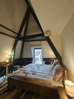 a bedroom with a large bed in a room at Alkmaar canal apartment in Alkmaar