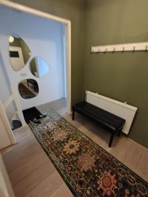 a living room with a bench and a rug at Alkmaar canal apartment in Alkmaar