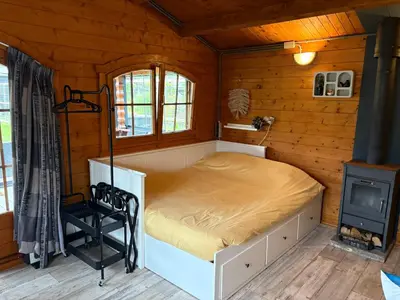 a bedroom with a bed in a wooden cabin at De Narcis in Lisse