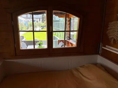 a bed in a room with two windows at De Narcis in Lisse