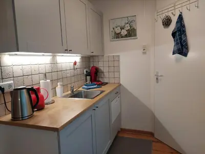 a kitchen with white cabinets and a sink at Hagerstudio in Huizen