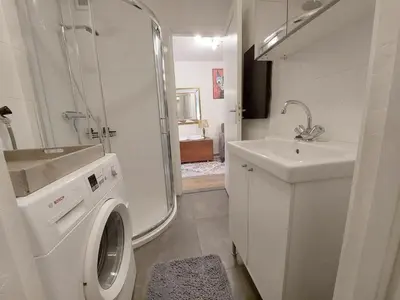 a bathroom with a washing machine and a sink at Hagerstudio in Huizen