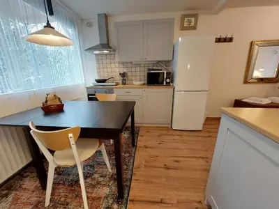 a kitchen with a black table and a white refrigerator at Hagerstudio in Huizen