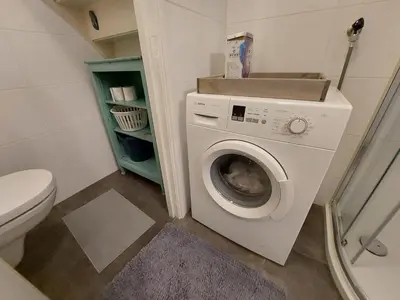 a bathroom with a washing machine and a toilet at Hagerstudio in Huizen
