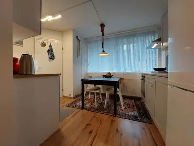 a kitchen with a table and chairs in a room at Hagerstudio in Huizen
