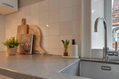 a kitchen counter with a sink and a book at Boutique Hoeve de Berg in Uitgeest