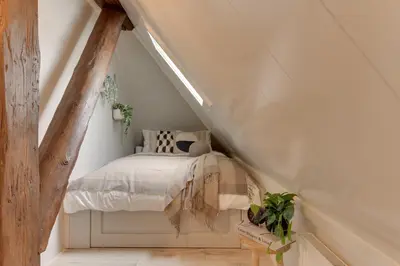 a bedroom with a bed in a attic at Boutique Hoeve de Berg in Uitgeest