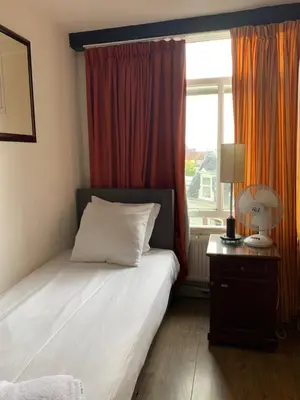 a bedroom with a bed and a window with at Hotel La Belle Vue in Amsterdam